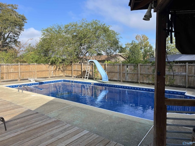 view of swimming pool featuring a water slide and a diving board