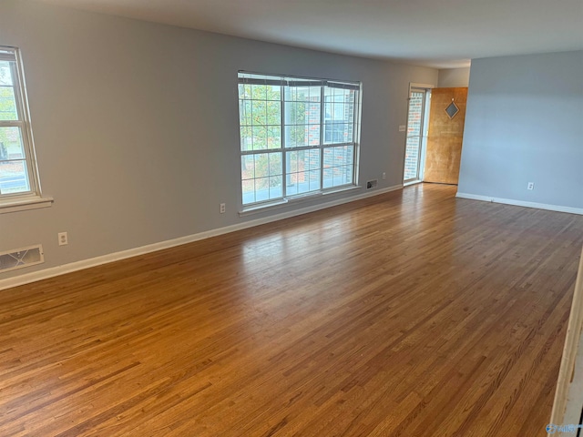 unfurnished room featuring hardwood / wood-style floors and plenty of natural light