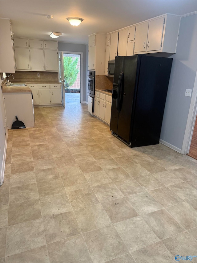 kitchen with black appliances, tasteful backsplash, sink, and white cabinets