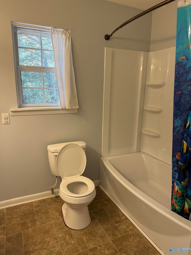 bathroom featuring toilet and shower / bath combination with curtain