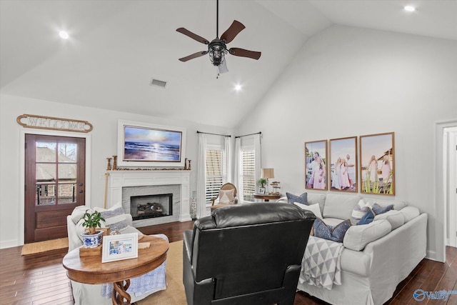 living room featuring ceiling fan, high vaulted ceiling, dark hardwood / wood-style floors, and a healthy amount of sunlight