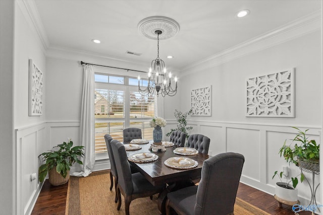 dining area featuring ornamental molding, a notable chandelier, and dark hardwood / wood-style flooring