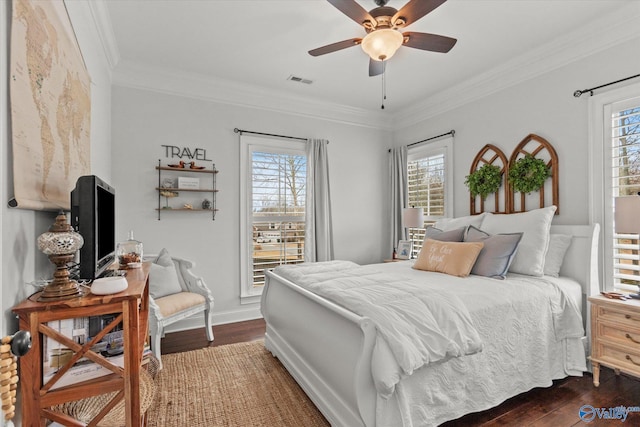 bedroom featuring multiple windows, crown molding, dark hardwood / wood-style floors, and ceiling fan