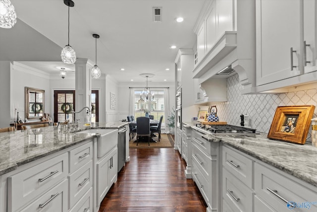 kitchen featuring hanging light fixtures, white cabinets, and appliances with stainless steel finishes