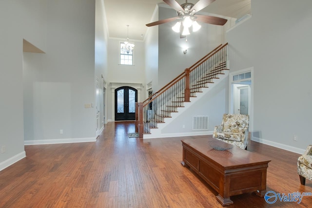 entryway featuring a high ceiling, dark hardwood / wood-style flooring, french doors, and crown molding