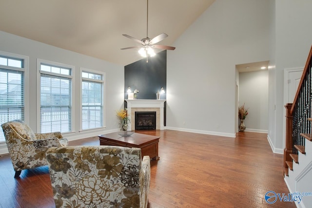 living room with a wealth of natural light, high vaulted ceiling, and wood-type flooring