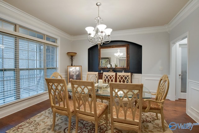 dining area featuring dark hardwood / wood-style floors, ornamental molding, and an inviting chandelier