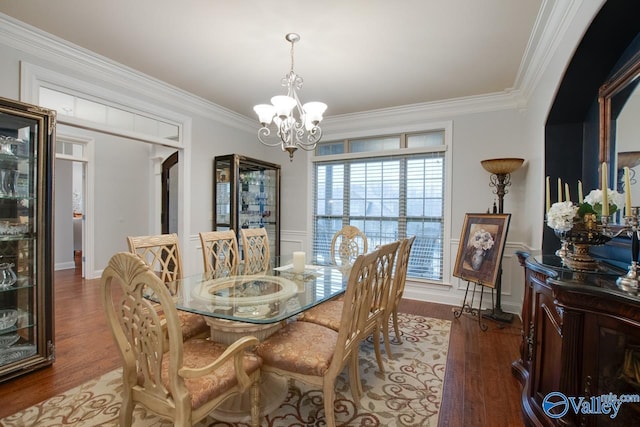 dining area with a notable chandelier, wood-type flooring, and crown molding