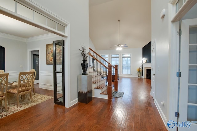 foyer entrance featuring dark hardwood / wood-style floors, high vaulted ceiling, ceiling fan, and ornamental molding