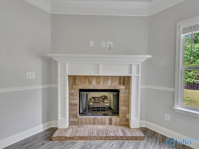 interior details with baseboards, ornamental molding, wood finished floors, and a fireplace