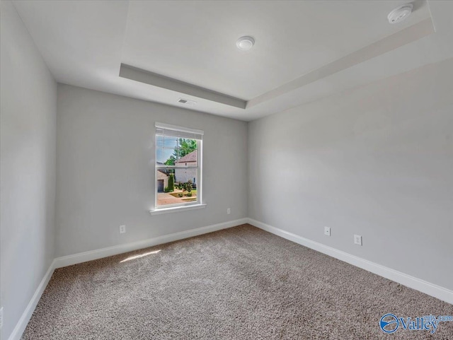unfurnished room featuring baseboards, visible vents, carpet floors, and a raised ceiling