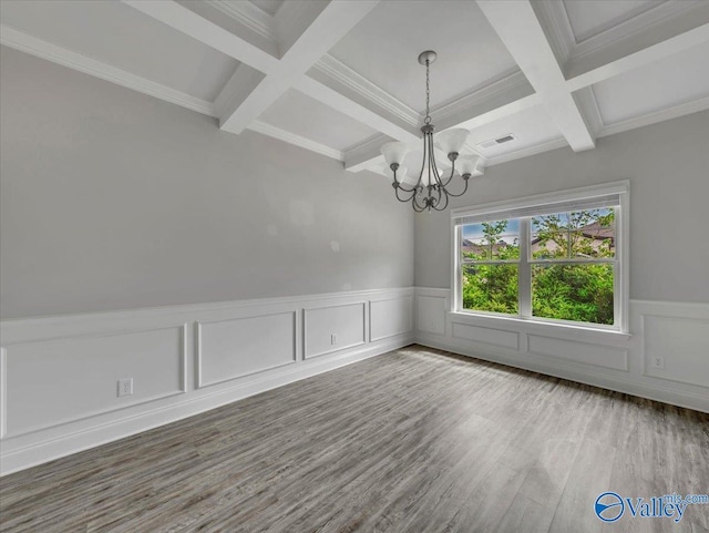 spare room with wood finished floors, beam ceiling, a notable chandelier, and coffered ceiling