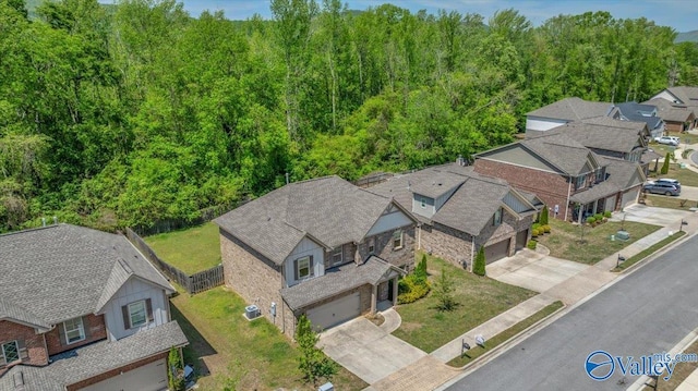 drone / aerial view featuring a view of trees and a residential view