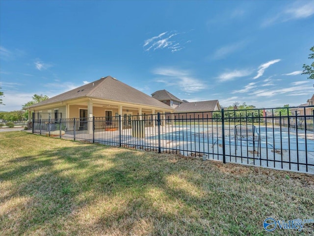 rear view of house featuring fence, a yard, a patio, and a fenced in pool