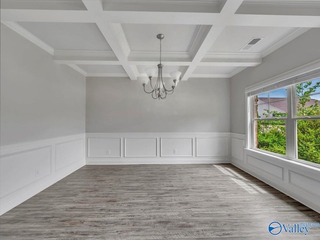empty room with wood finished floors, an inviting chandelier, coffered ceiling, beam ceiling, and visible vents