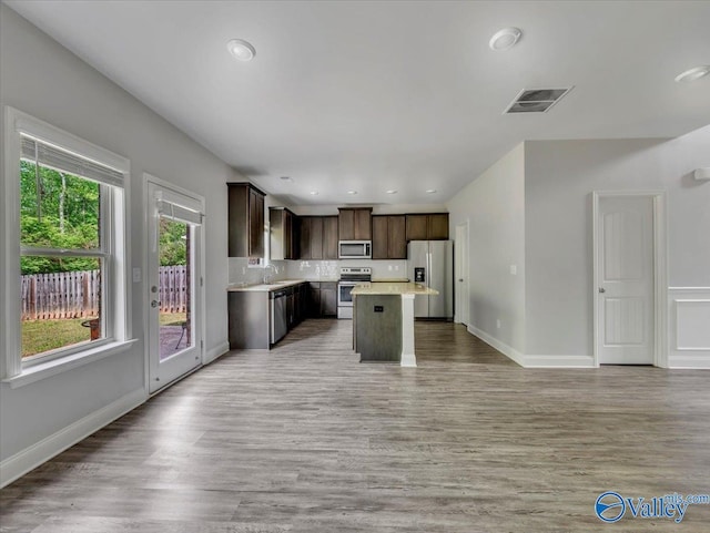kitchen with light countertops, dark brown cabinets, visible vents, a sink, and appliances with stainless steel finishes