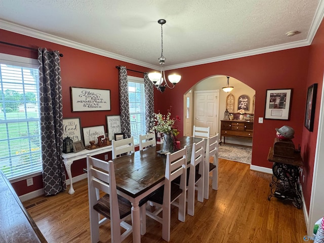 3648 Turnpike Rd, Albertville, AL 35950 - dining room featuring arched walkways, light wood-style floors, healthy amount of natural light, baseboards, and crown molding