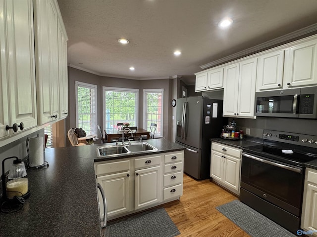3648 Turnpike Rd, Albertville, AL 35950 - kitchen featuring appliances with stainless steel finishes, a sink, ornamental molding, dark countertops, and a peninsula