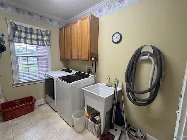 3648 Turnpike Rd, Albertville, AL 35950 - laundry room featuring washing machine and dryer, cabinet space, ornamental molding, light tile patterned floors, and baseboards