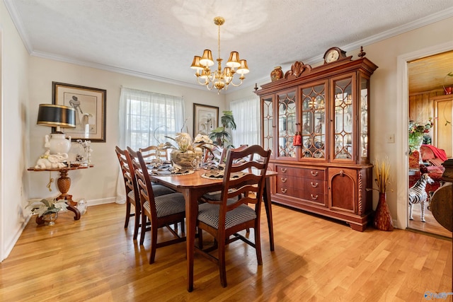 dining space featuring a textured ceiling, light wood-type flooring, crown molding, and an inviting chandelier