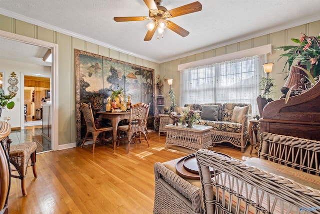 sitting room with a textured ceiling, hardwood / wood-style flooring, ceiling fan, and ornamental molding