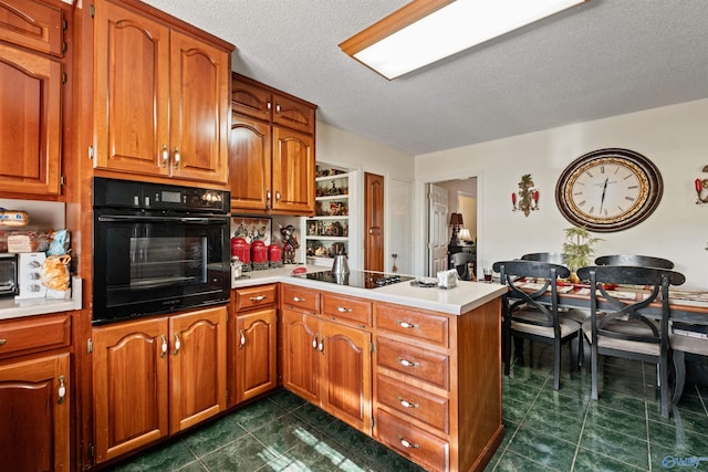 kitchen with kitchen peninsula, a textured ceiling, dark tile patterned floors, and black appliances