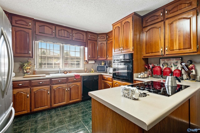 kitchen featuring black appliances, kitchen peninsula, and a textured ceiling