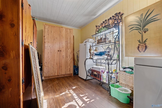 misc room featuring wood-type flooring and wooden walls