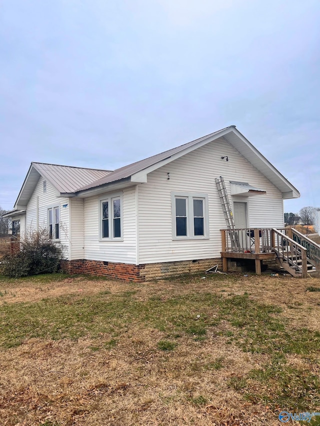 rear view of property featuring metal roof, a yard, and crawl space