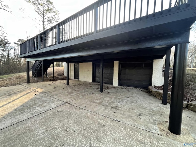 view of patio / terrace featuring stairway, a garage, a deck, a carport, and driveway