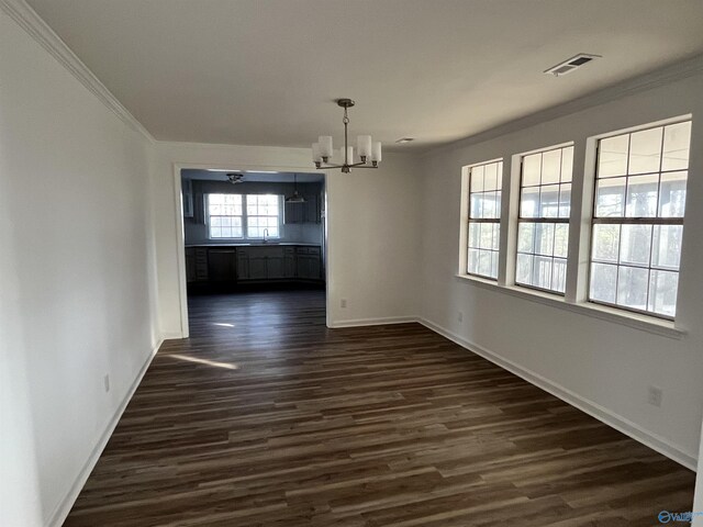 unfurnished dining area featuring dark wood-style floors, visible vents, ornamental molding, a chandelier, and baseboards