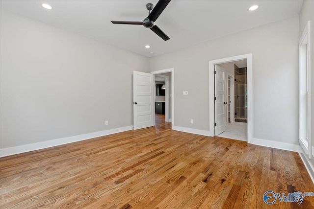 unfurnished bedroom with ensuite bathroom, ceiling fan, and light wood-type flooring