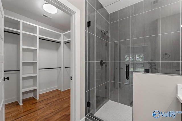 bathroom featuring an enclosed shower and wood-type flooring