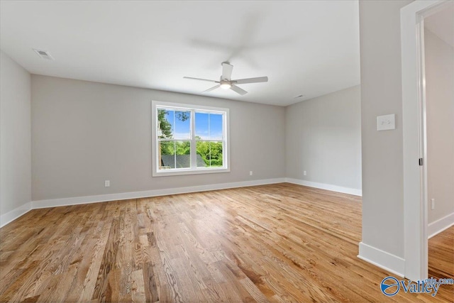 empty room with ceiling fan and light hardwood / wood-style flooring