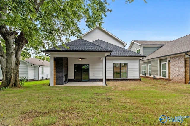 back of property with a yard, ceiling fan, and a patio area