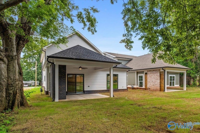 rear view of property featuring a lawn, a patio, and ceiling fan