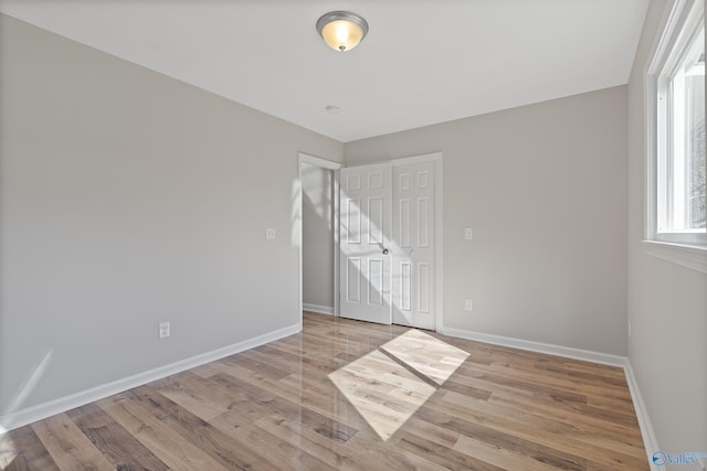 unfurnished room featuring light wood-type flooring and baseboards