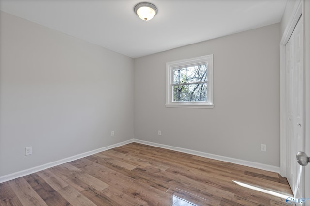 unfurnished bedroom featuring a closet, baseboards, and wood finished floors