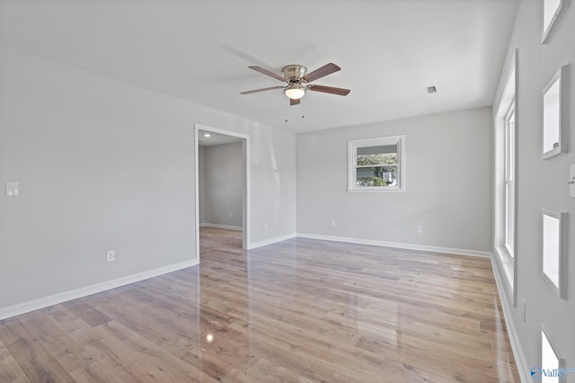 unfurnished room featuring light wood-style flooring, visible vents, baseboards, and a ceiling fan