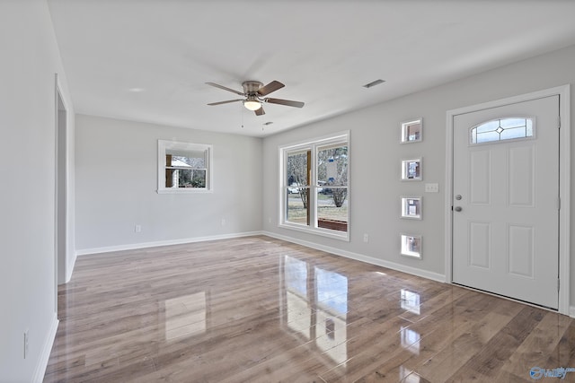 foyer featuring ceiling fan, light wood-style floors, visible vents, and baseboards