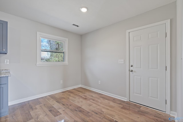 interior space featuring light wood-style floors, visible vents, and baseboards