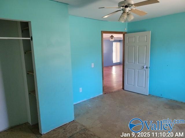 unfurnished bedroom featuring ceiling fan, concrete floors, and a closet