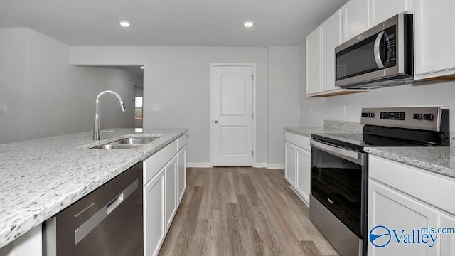 111 Wellspring Rd, Huntsville, AL 35810 - kitchen with stainless steel appliances, a sink, light wood-type flooring, light stone countertops, and white cabinetry