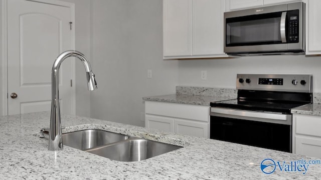 111 Wellspring Rd, Huntsville, AL 35810 - kitchen with stainless steel appliances, a sink, white cabinets, and light stone counters