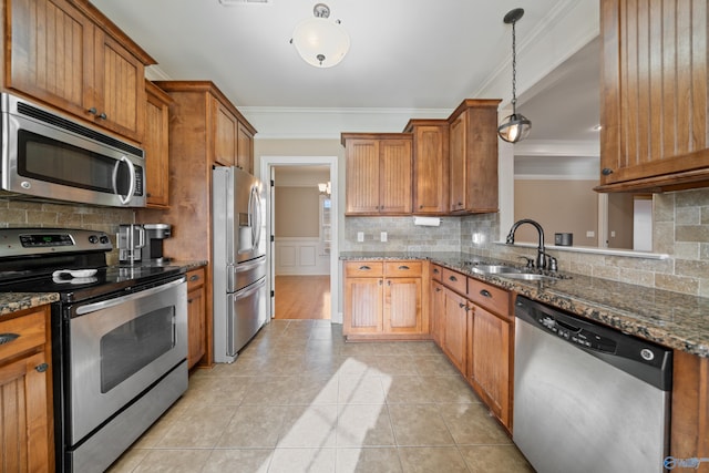 kitchen with crown molding, appliances with stainless steel finishes, brown cabinetry, and a sink