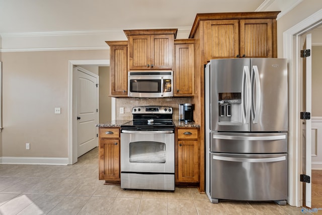 kitchen featuring brown cabinets, stone counters, stainless steel appliances, and decorative backsplash