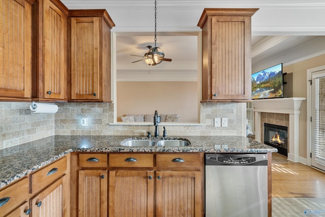 kitchen with ornamental molding, stainless steel dishwasher, a sink, and brown cabinets