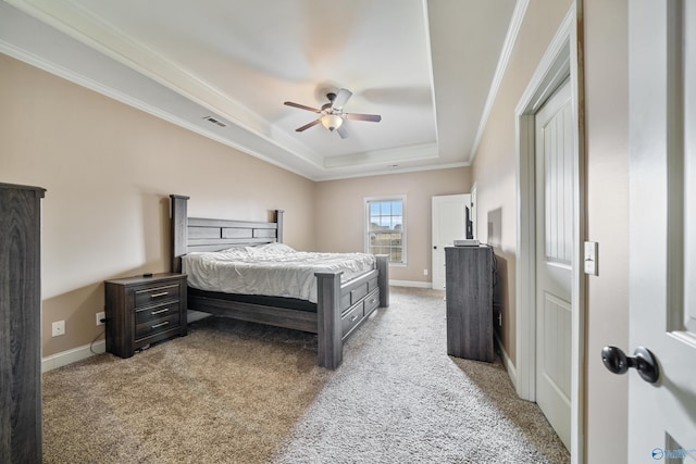 bedroom featuring ornamental molding, a tray ceiling, baseboards, and light colored carpet