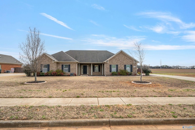 ranch-style house with a front yard and brick siding