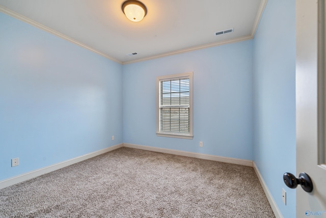 spare room with baseboards, carpet floors, visible vents, and crown molding